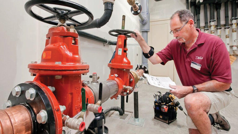 A man checking on a backflow preventer